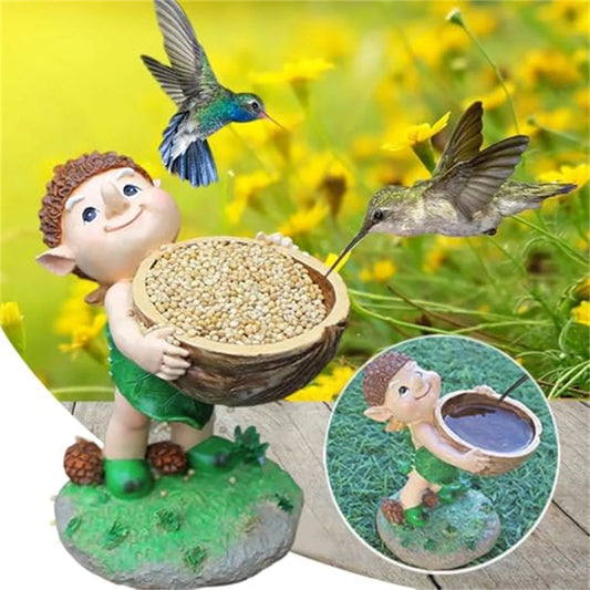 A whimsical elf-like figure holds a walnut-shaped bird feeder filled with seeds, with hummingbirds flying nearby.